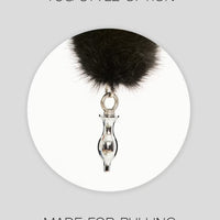 a black furry ball hanging from a metal hook